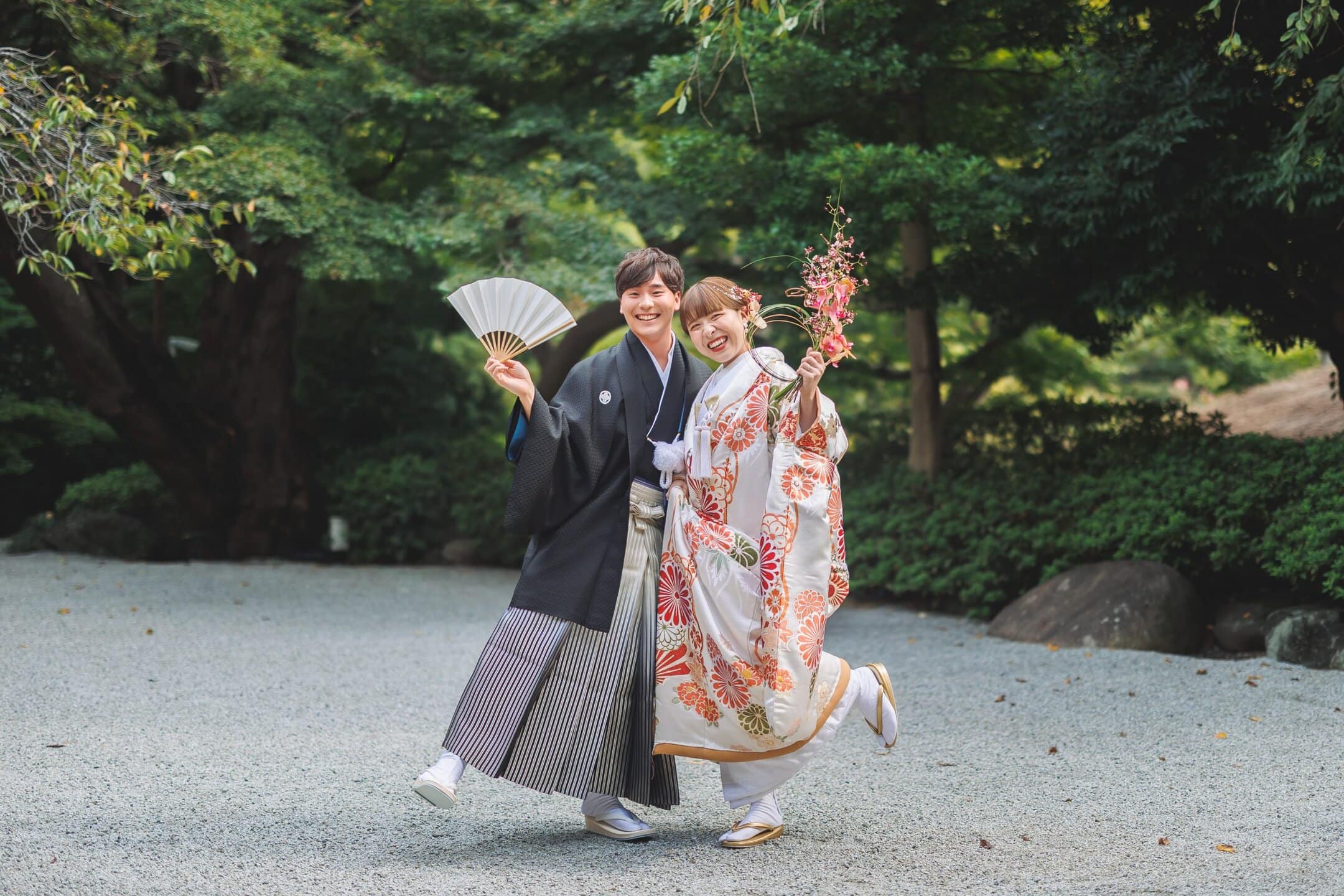 日本庭園で笑顔の新郎新婦、伝統的な和装と幸せな瞬間.