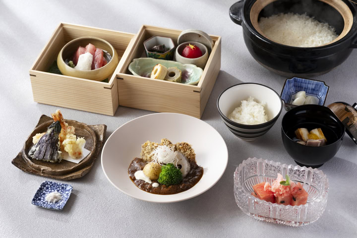 伝統的な日本料理の盛り付け例、刺身、天ぷら、ご飯、味噌汁、デザートを含む豪華な和食セット.