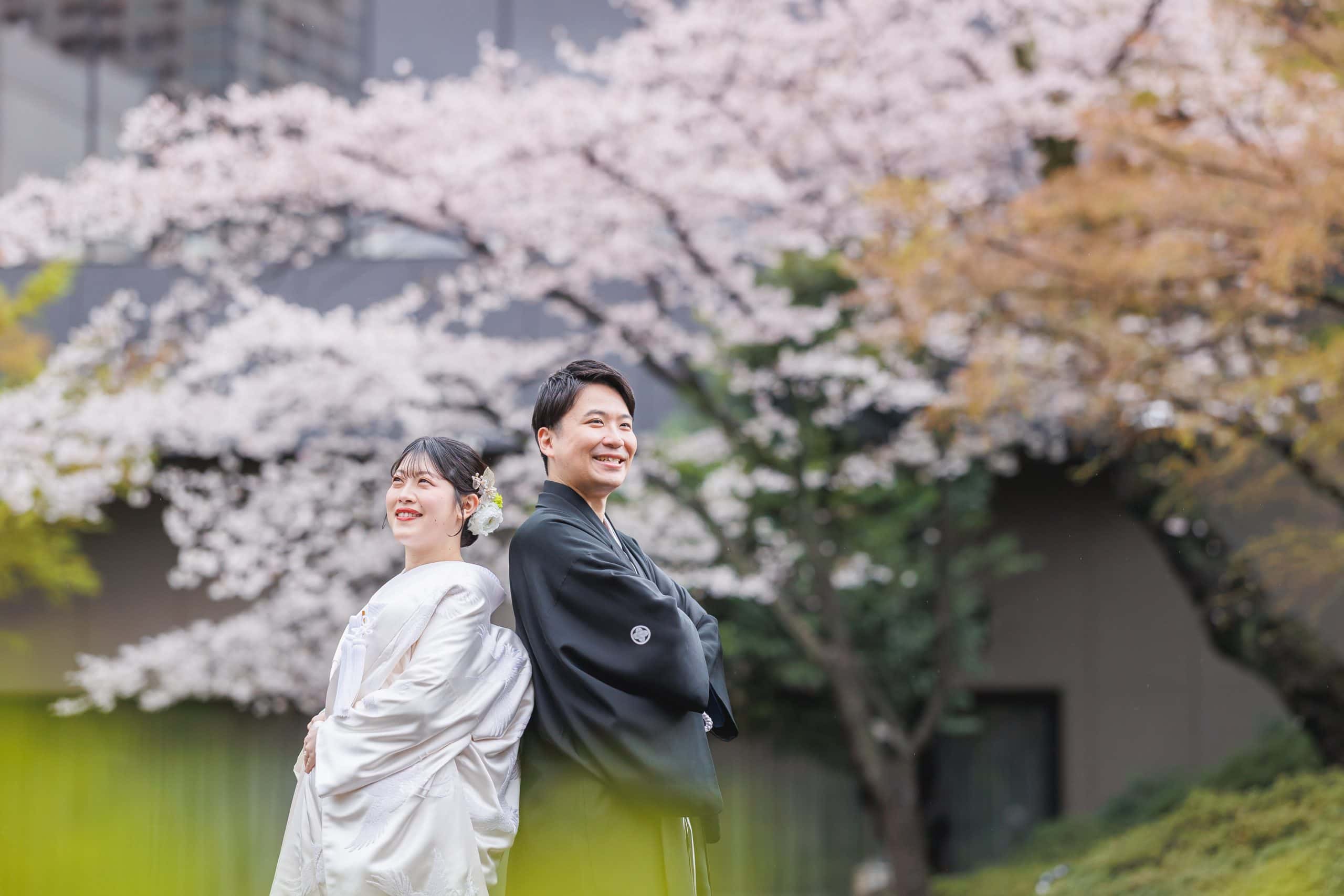 春の庭園で和装のカップルが笑顔で記念撮影を楽しむ風景.