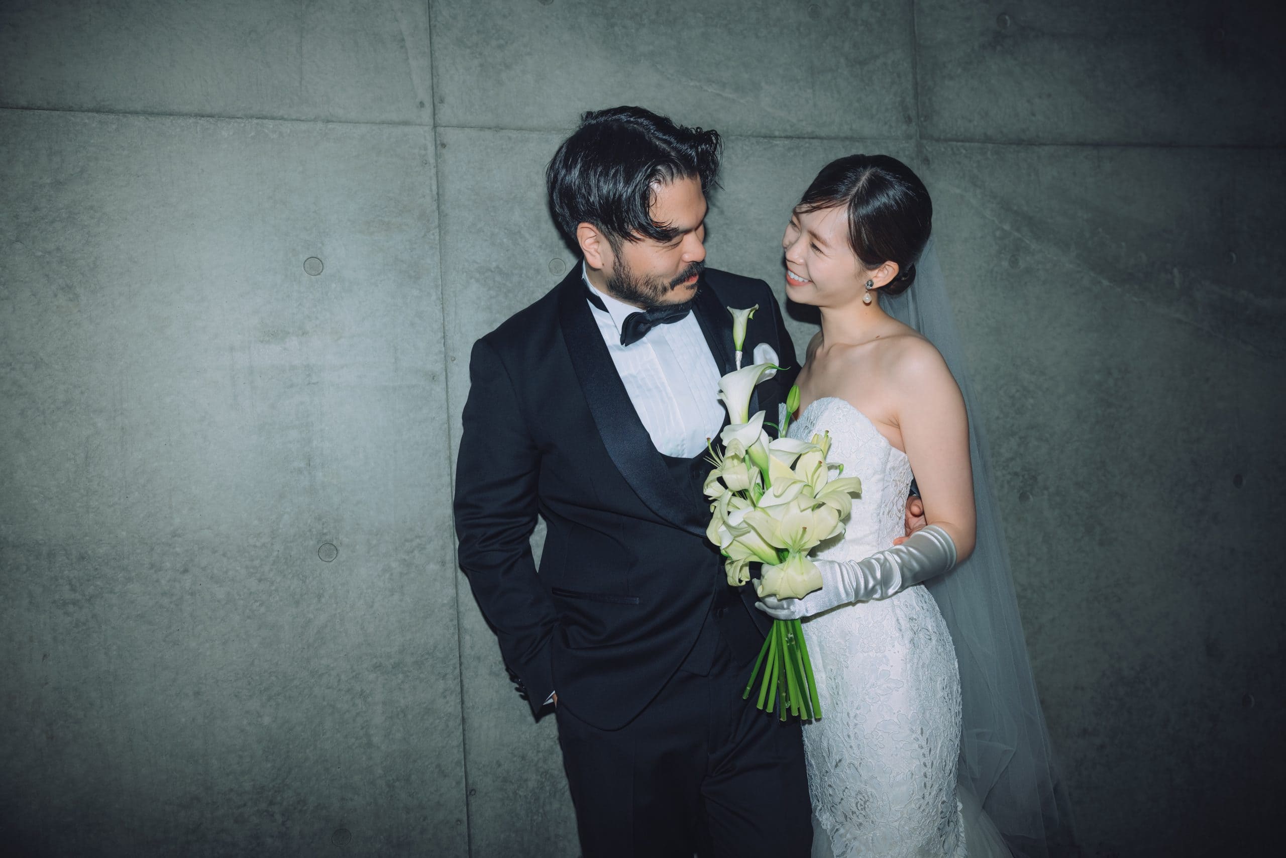 結婚式の新郎新婦が笑顔で見つめ合うロマンチックなシーン.