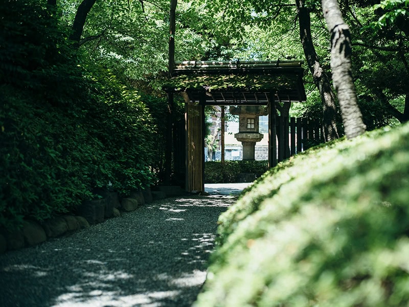 緑豊かな庭園の小道と伝統的な鳥居の風景。結婚式や和装の写真に最適な美しい日本の庭園風景。.