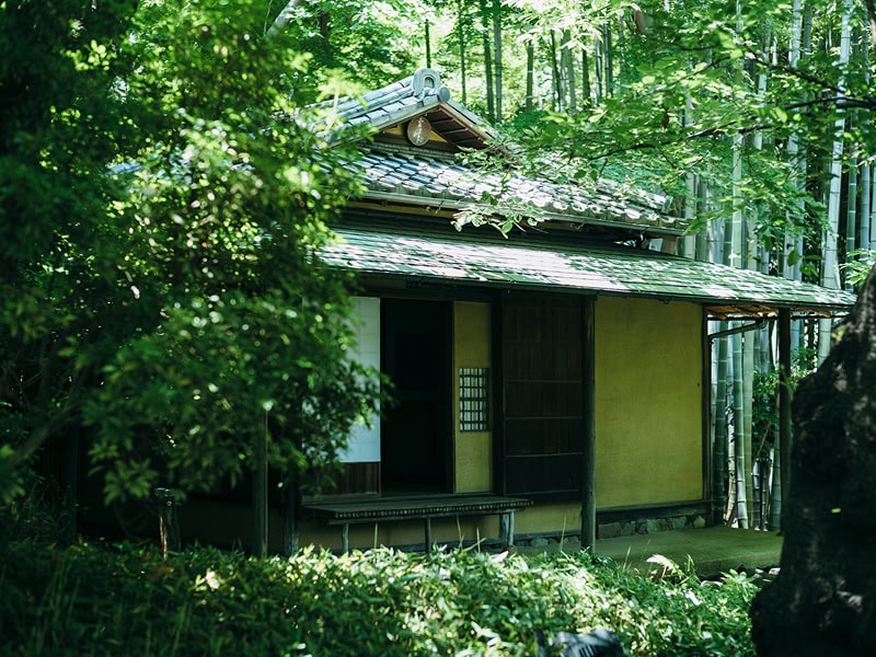 日本の伝統的な庭園に佇む古民家風の結婚式会場、緑豊かな自然に囲まれた静かなロケーション.