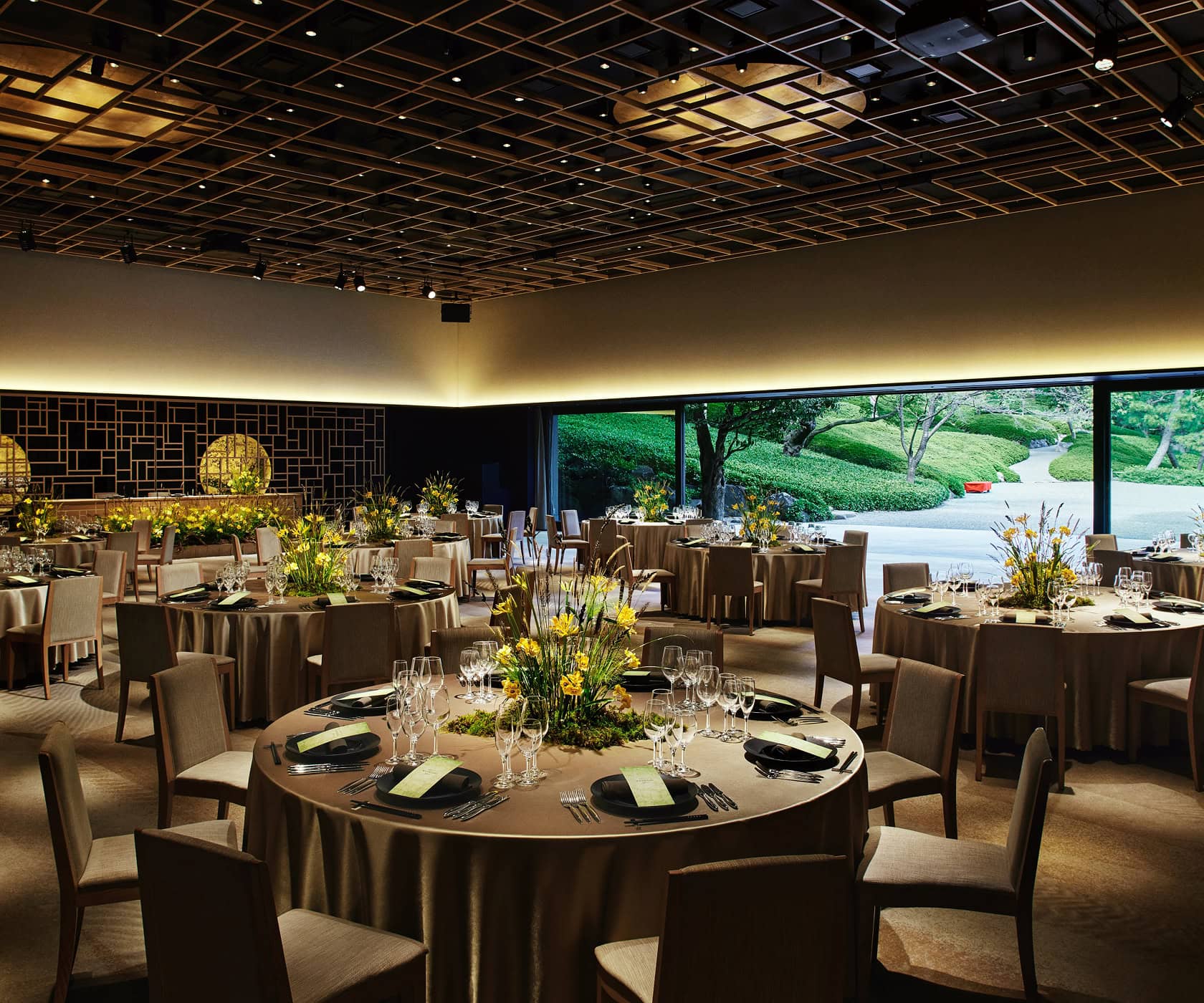 The wedding venue boasts luxurious interior decorations and a view of a Japanese garden through its large windows.