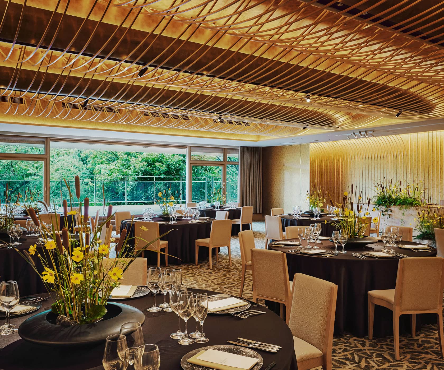 The wedding venue boasts luxurious interior decorations and table settings, and a space with windows offering views of lush greenery.